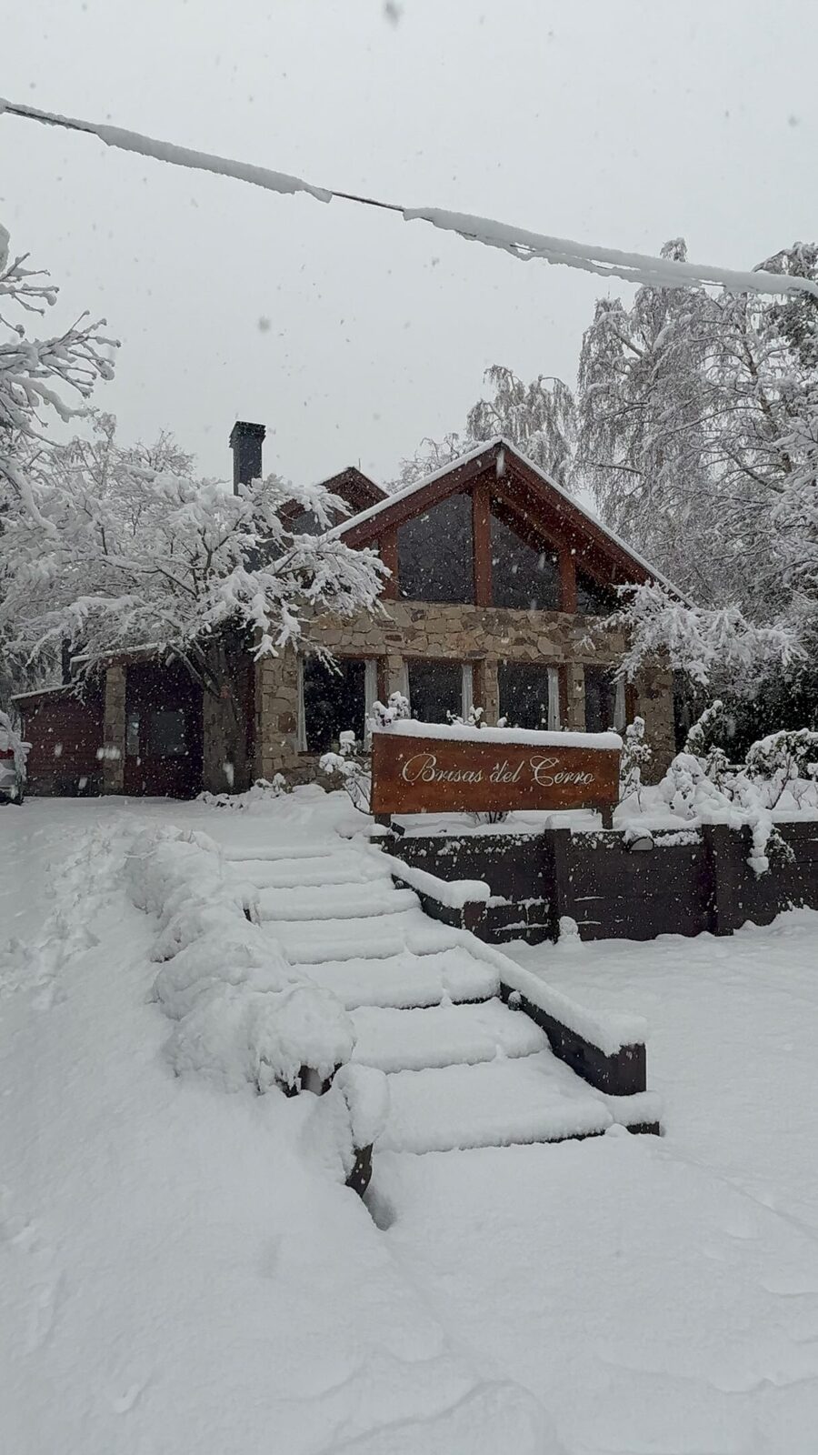 Escalera y cartel de la hostería cubiertos de nieve